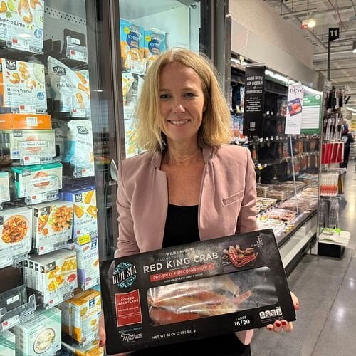 Sjømatutsending til USA, Karine Rød Haraldsson med kongekrabbe-produkt i butikk.