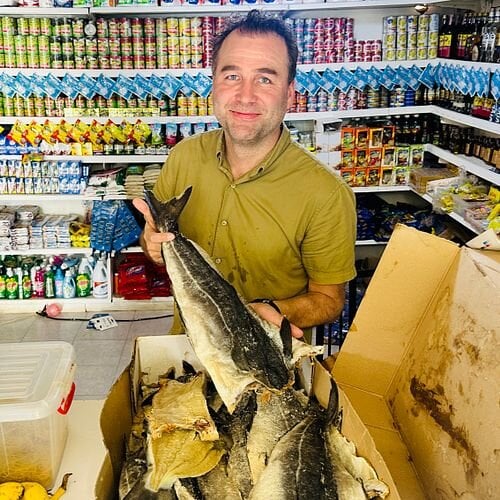 Mange dominkanere kjøper klippfisk over disk i nærbutikken sin. Fisken deles i biter etter ønsket mengde. Her er det Sjømatrådets Ørjan Kjærvik Olsen som får prøve seg som butikkansatt.