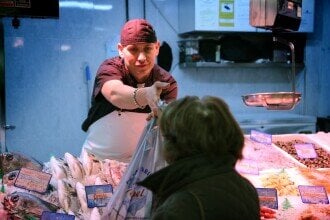 En kvinne handler fisk fra fiskedisk.