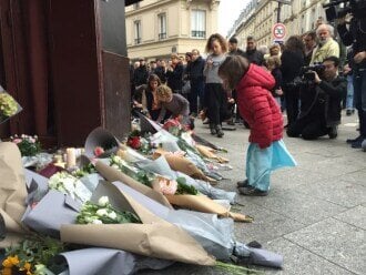 Folk står rundt minnested i Paris etter terrorangrep.