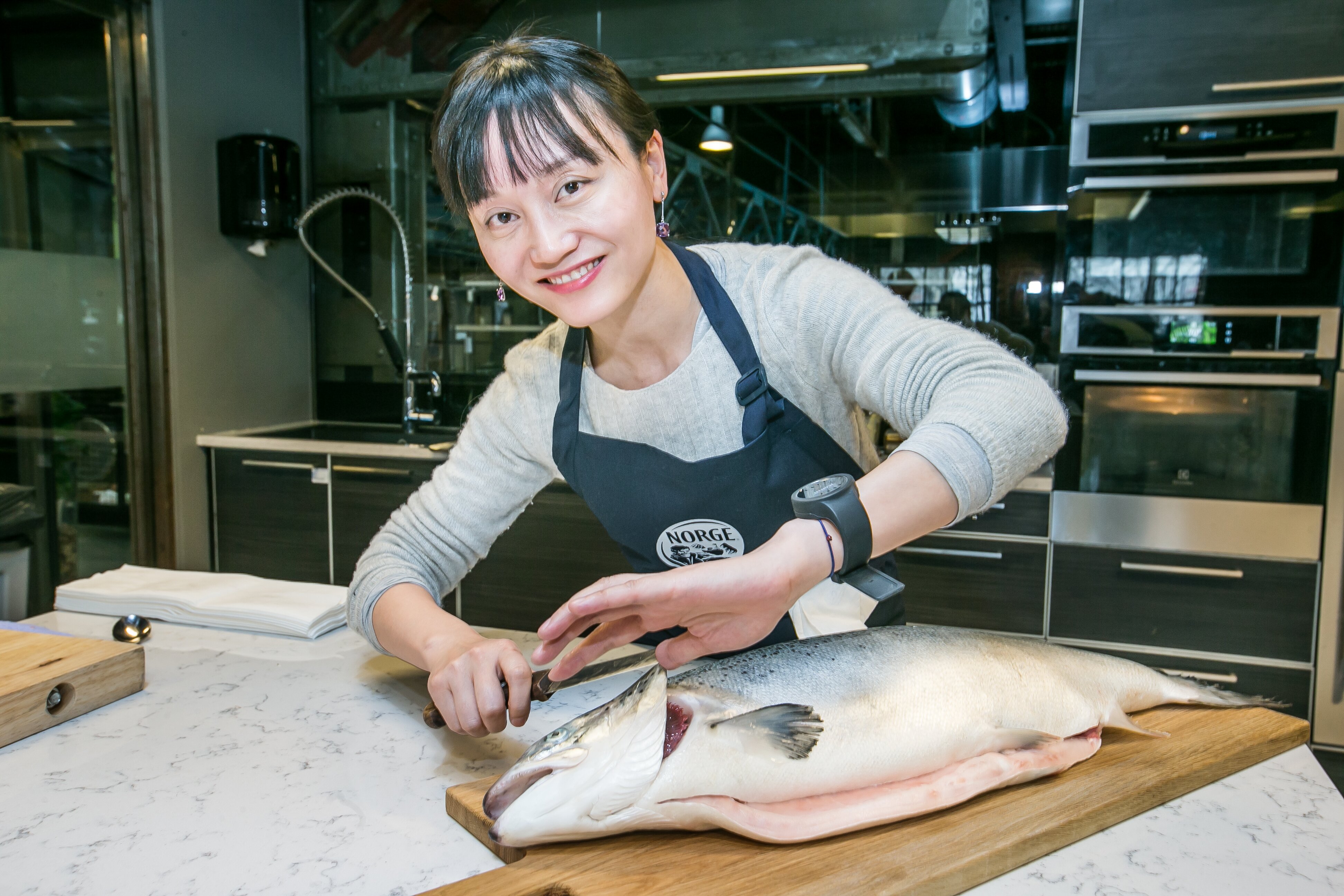 Jiang Zheng fikk prøve å filetere en laks under besøket på Mathallen i Oslo.